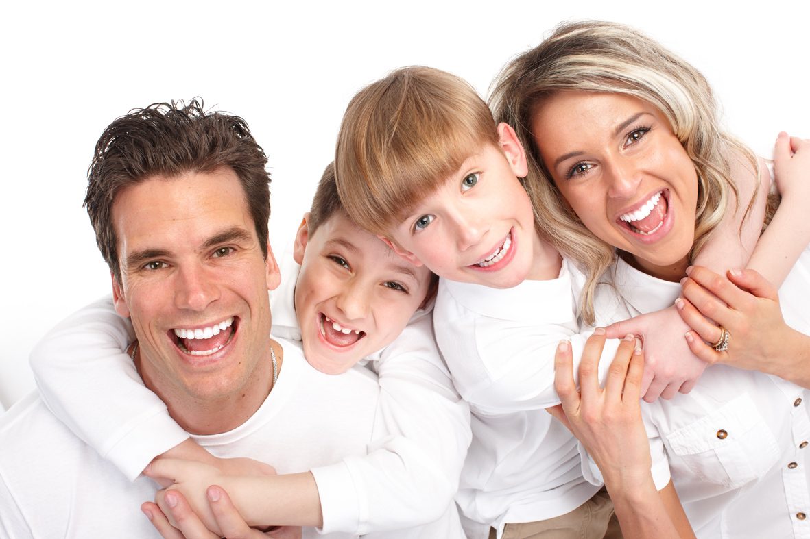 Familia sonriente mostrando una dentadura sana y cuidada